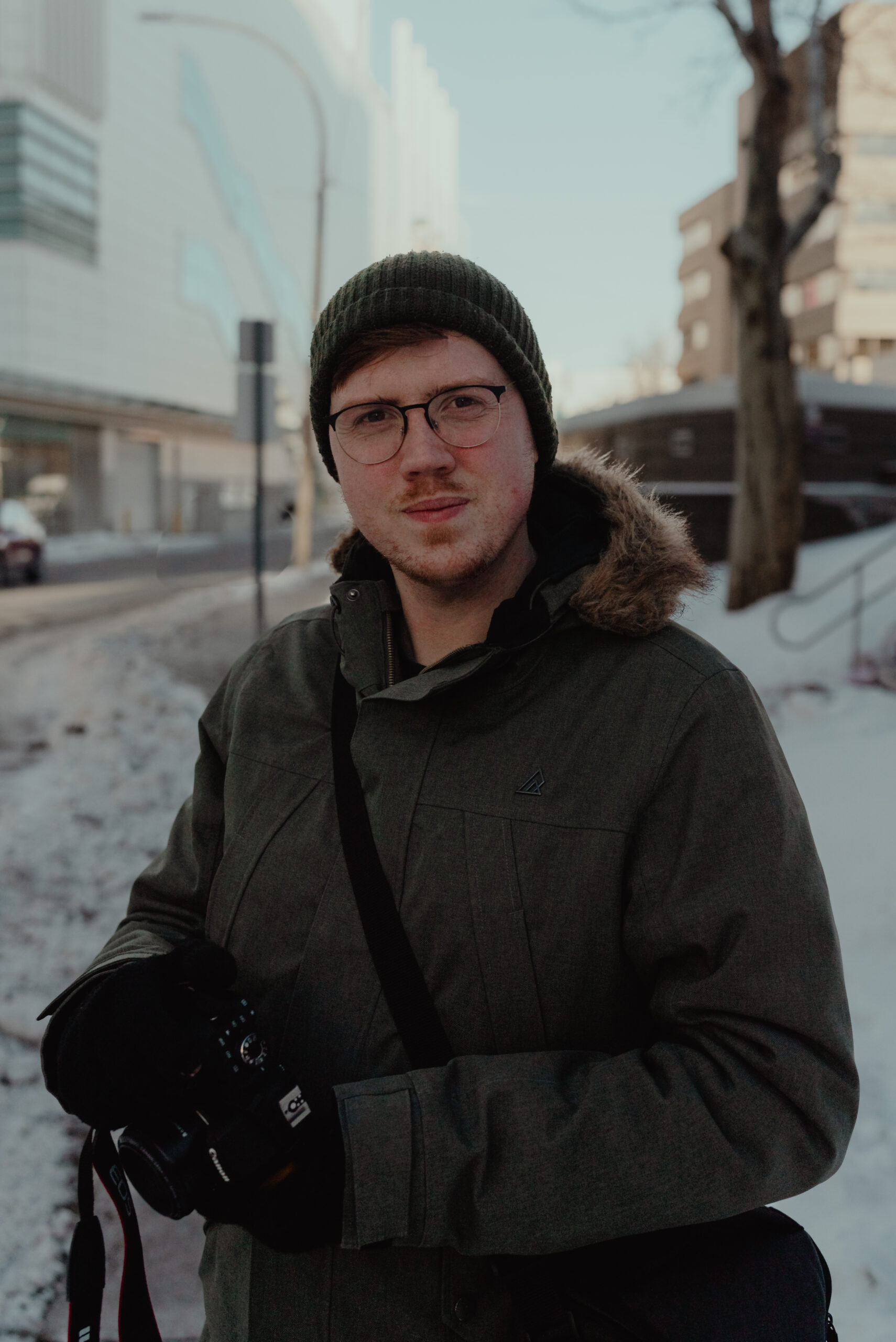 With Care Media founder "Addison John" holding a Canon Camera.