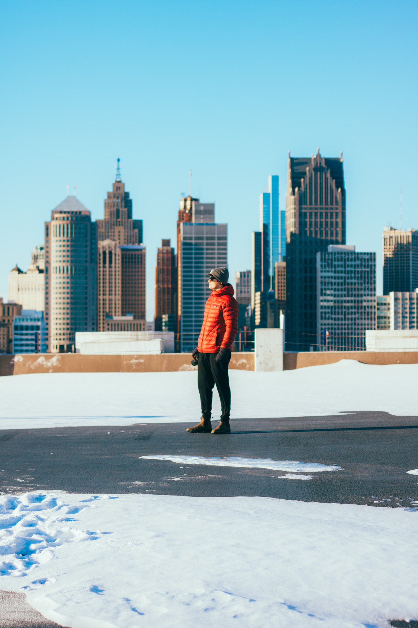 man standing overlooking detroits skyline.